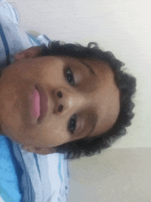 a young boy with curly hair is laying on a bed