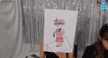 a woman is holding up a drawing of a woman with a microphone in her hand .