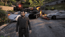 a man in a suit is standing in front of a bunch of cars on fire