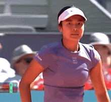 a woman wearing a nike hat and a purple shirt with the number 4 on the bottom