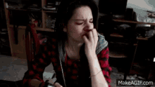 a woman in a plaid shirt is sitting in a chair holding a piece of paper in her hand ..