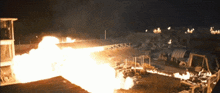 a large fire is coming out of a building in the dark