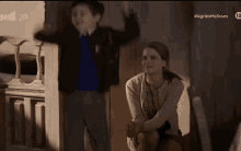 a boy and a girl are sitting next to each other in a room and the boy is laughing .