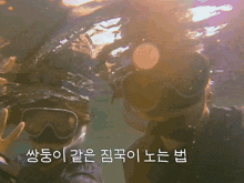 a man and a woman are swimming in the water with korean writing on the bottom