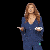 a woman in a blue jumpsuit is holding a white object