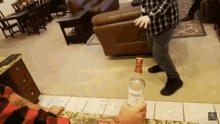 a man is holding a bottle of smirnoff vodka in his hand