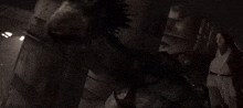 a man in a white robe is standing in a dark room with a mask on his face .