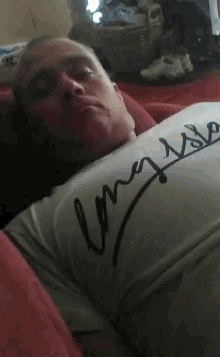 a man wearing a long island shirt is sleeping on a couch