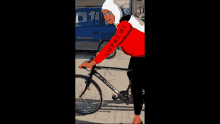 a person wearing a red and white supreme hoodie rides a bike