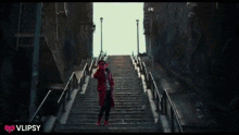 a man standing on a set of stairs with the words " finally it 's friday " behind him