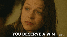 a close up of a woman 's face with the words " you deserve a win " above her
