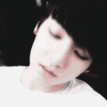 a close up of a young man with his eyes closed