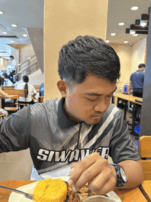a man wearing a shirt with the word siwaver on it
