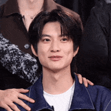 a close up of a man 's face with a person 's hand on his shoulder