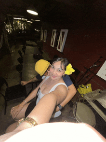 a woman with a yellow flower in her hair sits on a man 's back