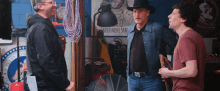 a man in a cowboy hat talks to two other men