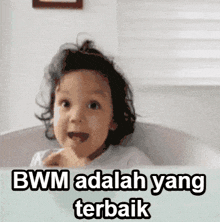 a baby is sitting in a bathtub with the words bwm adalah yang terbaik below it