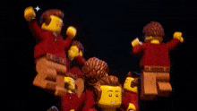 a bunch of lego figures are dancing together