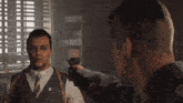 a man is pointing a gun at another man .