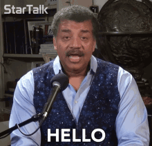 a man talking into a microphone with the word hello written on his face
