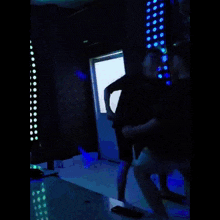 a man in a black shirt is standing in a dark room