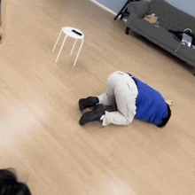 a person is laying on the floor with their head on a stool