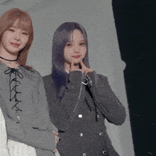 a girl with purple hair stands next to another girl