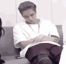 a man is sitting in a chair with his legs crossed and a book in his lap .