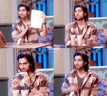 a man in a plaid shirt is sitting at a table holding a piece of paper in his hand