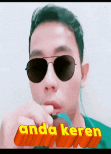 a man wearing sunglasses has the word anda keren written above him