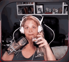 a woman wearing headphones is holding a glass of wine in front of a microphone that says i can 't adult today
