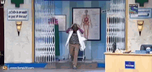 a man in a lab coat is walking into a room with a sign that says sony on it