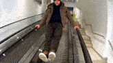a man is riding an escalator and smoking a cigarette .