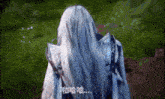a person with long white hair is wearing a blue coat