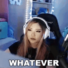 a woman wearing headphones is sitting in front of a computer and the word whatever is written on the screen .