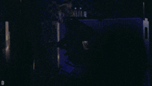 a person stands in front of a microphone in a dark room
