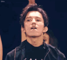 a close up of a man 's face with a woman in the background .