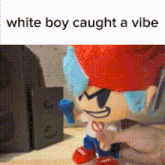 a stuffed toy of a white boy is sitting on a table .