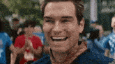 a close up of a man smiling with his mouth open in front of a crowd .