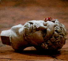 a statue of a man laying on the floor with blood on his face