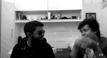 a black and white photo of two men wearing sunglasses