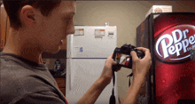 a man takes a picture in front of a dr. pepper vending machine