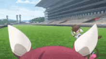 a person is running on a field with a stadium in the background .