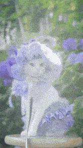 a white cat wearing a purple and white hat