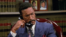 a man in a suit is talking on a phone
