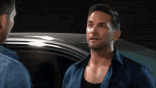 a man in a blue shirt talks to another man