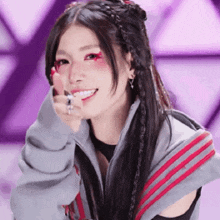 a woman wearing a gray and red striped jacket is smiling .
