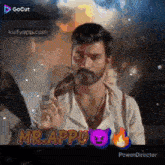a man with a beard is smoking a cigarette in front of a fire and the words mr.appu on the bottom