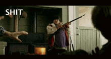 a man is holding a shotgun in front of a fireplace with the word shit above him