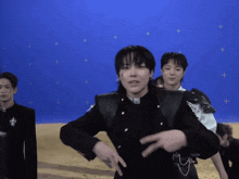 a group of young men are standing in front of a blue screen